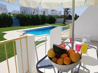 a table with a vase of flowers on a balcony at Villa Sunshine in Albufeira