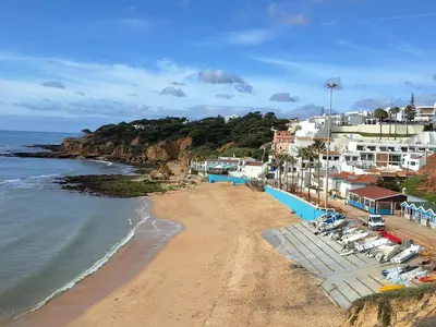 a beach with a group of buildings and the ocean at Villa Sunshine in Albufeira