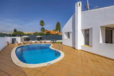 a swimming pool in the backyard of a house at Villa Amendoeira by Villa Plus in Albufeira