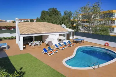 a patio with a pool and chairs and a house at Villa Buganvillea by Villa Plus in Albufeira