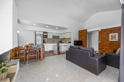 a living room and kitchen with a couch and a table at Villa Buganvillea by Villa Plus in Albufeira