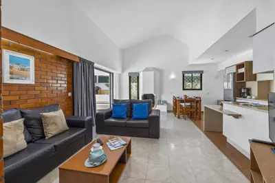 a living room with two couches and a kitchen at Villa Buganvillea by Villa Plus in Albufeira