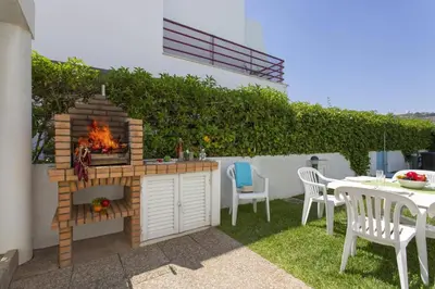 a outdoor kitchen with a fire grill in a yard at Villa Marina Azul by Villa Plus in Albufeira