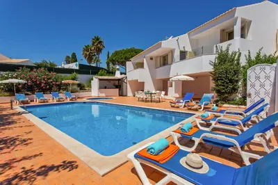 a villa with a swimming pool and lounge chairs at Villa Papi by Villa Plus in Albufeira