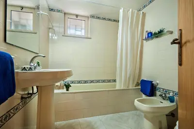 a bathroom with a sink and a toilet and a tub at Villa Papi by Villa Plus in Albufeira