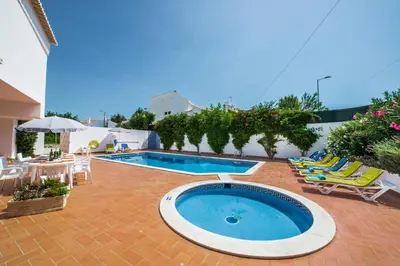 a swimming pool with lounge chairs and a patio with a swimming pool at Villa Papi by Villa Plus in Albufeira