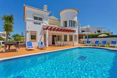 a villa with a swimming pool in front of a house at Villa Susana by Villa Plus in Albufeira