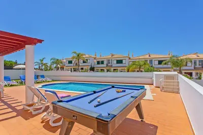 a pool table on a patio next to a swimming pool at Villa Susana by Villa Plus in Albufeira