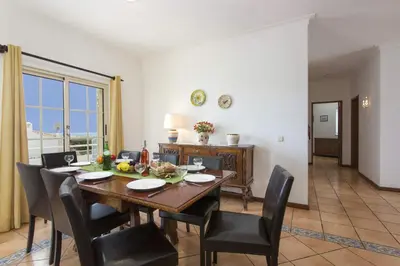 a dining room with a wooden table and chairs at Villa Primavera by Villa Plus in Albufeira