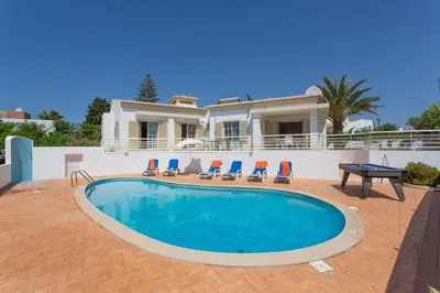 a swimming pool in front of a house at Villa Primavera by Villa Plus in Albufeira