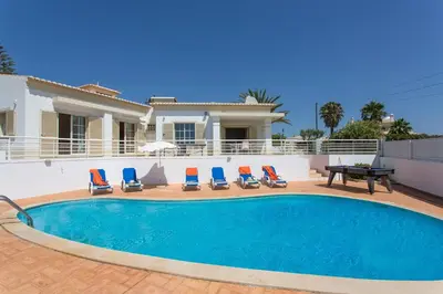 a villa with a swimming pool in front of a house at Villa Primavera by Villa Plus in Albufeira