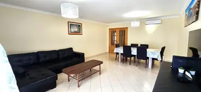 a living room with a black couch and a table at Holidays - Albufeira in Albufeira