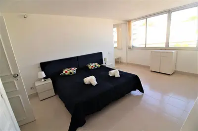 a bedroom with a black bed with two towels at Happy Place - Albufeira in Albufeira