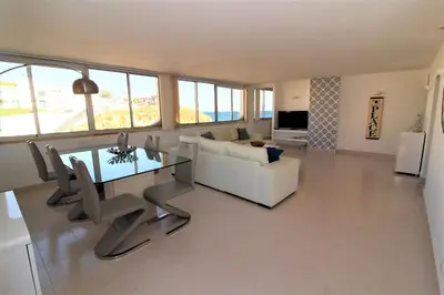 a living room with a table and a white couch at Happy Place - Albufeira in Albufeira