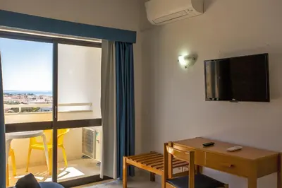 a room with a desk and a television on the wall at Sea View Apartment - 3 Swimming Pool & Fitness in Albufeira