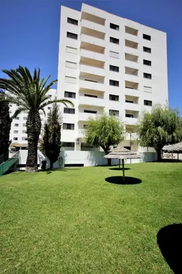 a park with a bench in front of a building at Sea View Apartment - 3 Swimming Pool & Fitness in Albufeira