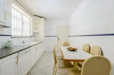 a kitchen with a table and chairs and a sink at Casa Europa in Vilamoura