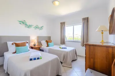 a hotel room with two beds and a window at Casa Europa in Vilamoura