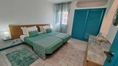 a bedroom with a bed with a green comforter at Casa da Praia by Sunny Deluxe in Albufeira