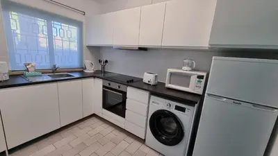 a kitchen with a washing machine and a microwave at Casa da Praia by Sunny Deluxe in Albufeira