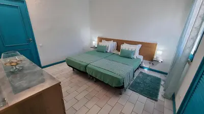 a bedroom with a bed with a green bedspread at Casa da Praia by Sunny Deluxe in Albufeira