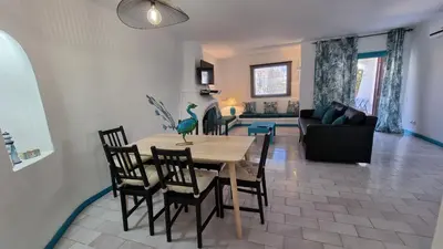 a dining room and living room with a table and chairs at Casa da Praia by Sunny Deluxe in Albufeira