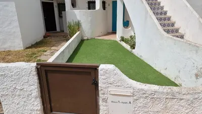 a door on the side of a building with green grass at Casa da Praia by Sunny Deluxe in Albufeira