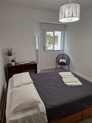 a bedroom with a bed with two towels on it at Apartamento T2 Palmeira Galé-Praia da Galé in Guia