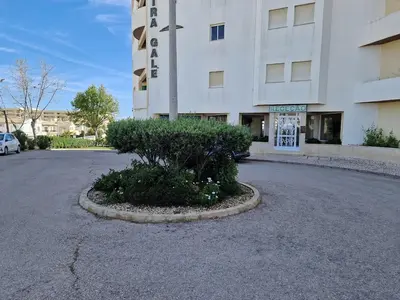 a parking lot in front of a building at Apartamento T2 Palmeira Galé-Praia da Galé in Guia