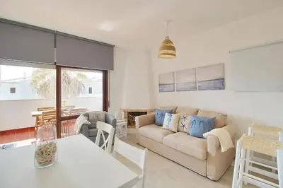 a living room with a couch and a table at Apt 1 Quarto, Piscina, AC, Varanda, Prestige For Home in Vilamoura