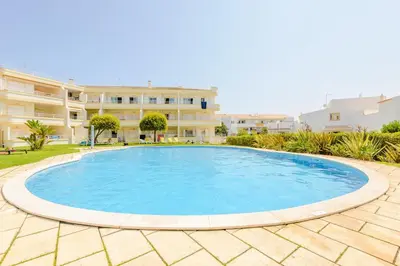 a large pool in the middle of a courtyard with a building at Grevilias in Vilamoura