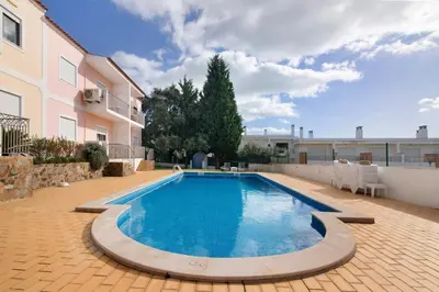 a swimming pool in a courtyard with a building at T1 Apartamentos Vista Alegre in Albufeira