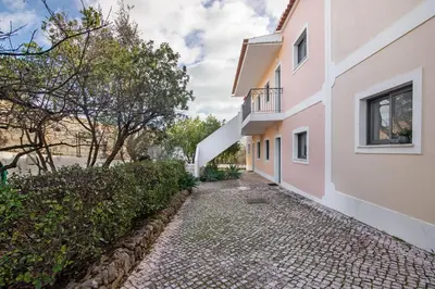 a walkway between two buildings with trees at T1 Apartamentos Vista Alegre in Albufeira