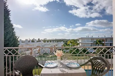 a table with two chairs on a balcony at T1 Apartamentos Vista Alegre in Albufeira