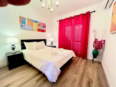 a bedroom with a bed with a red curtain at Vila Sophia, Vilamoura- By Urbinvest Algarve in Vilamoura