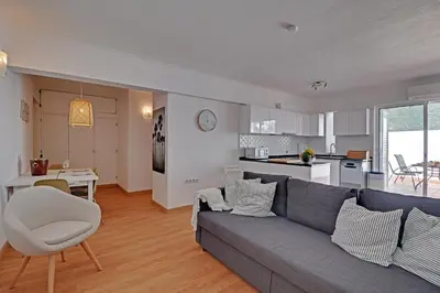 a living room with a blue couch and a kitchen at Casa Roos Loïs in Albufeira