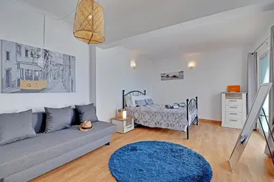 a living room with a couch and a bed at Casa Roos Loïs in Albufeira