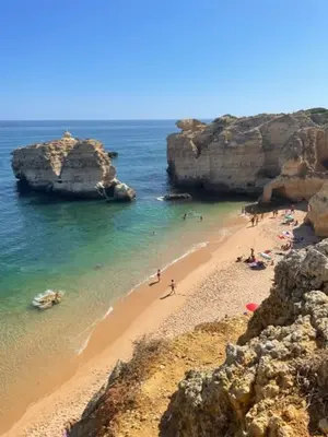 a group of people on a beach with rocks at Casa Roos Loïs in Albufeira