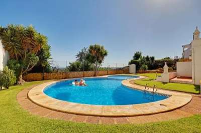 a family swimming in a pool in a yard at Casa Roos Loïs in Albufeira