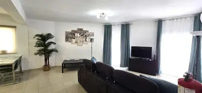 a white bedroom with a bed and a black dresser at Historic Centre B - Albufeira in Albufeira