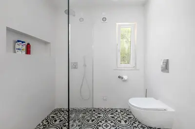 a white bathroom with a toilet and a shower at Villa Saragoça in Loulé