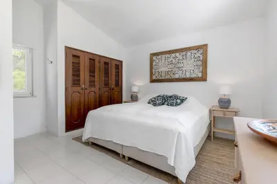 a white bedroom with a bed and a window at Villa Saragoça in Loulé