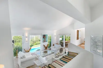 a living room with white furniture and a pool at Villa Saragoça in Loulé