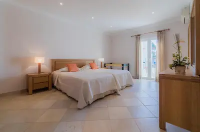a bedroom with a bed with orange pillows on it at Villa 29 by Garvetur in Vale do Lobo