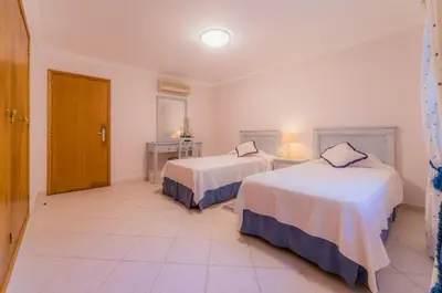 a hotel room with two beds and a bathroom at Villa 29 by Garvetur in Vale do Lobo