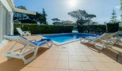 a patio with chairs and a swimming pool at Villa 29 by Garvetur in Vale do Lobo