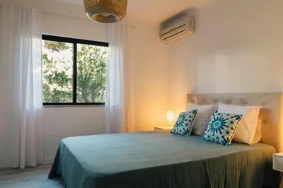 a bedroom with a bed with a large window at Falésia 25 in Albufeira