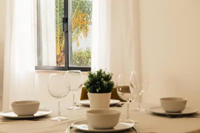 a table with wine glasses and a potted plant on it at Falésia 25 in Albufeira