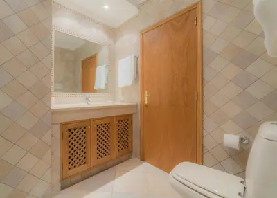 a bathroom with a toilet and a sink and a mirror at Villa Bota by Garvetur in Almancil