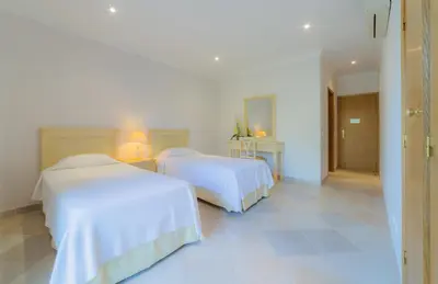 two beds in a room with white walls and tile floors at Villa Bota by Garvetur in Almancil